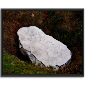 Un large bloc de glace disparait lentement dans le fond d’une doline, paysage karstique des Pyrénées.